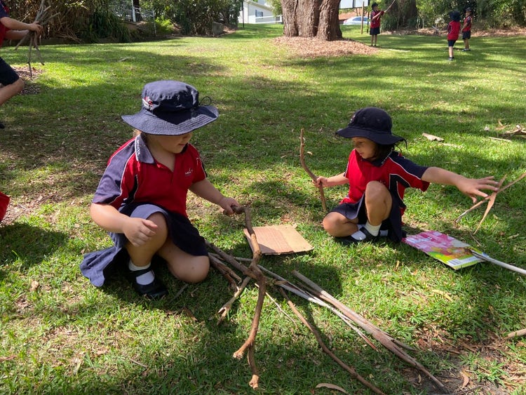 Children creating with natural and recycled materials such as sticks and cardboard